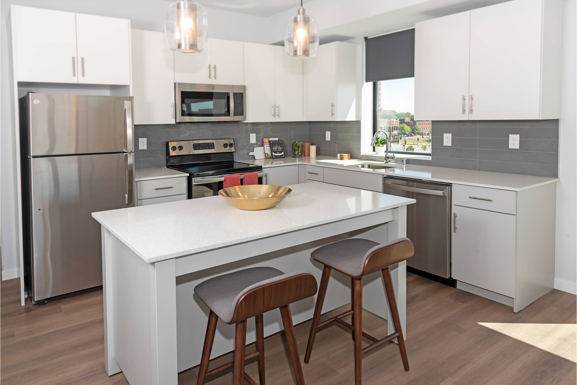 Modern kitchen with white cabinetry, stainless steel appliances, and island with seating.