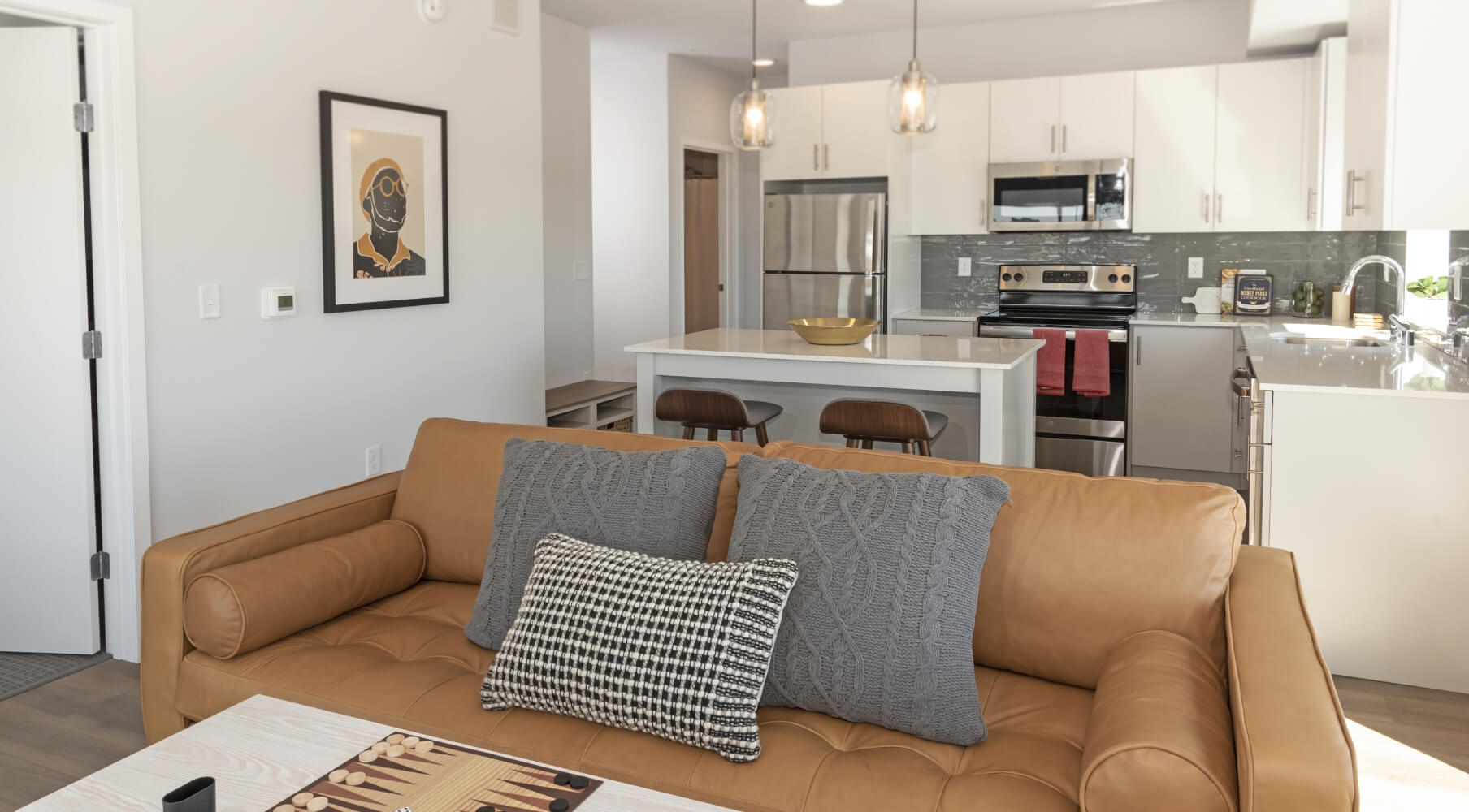 Everlake apartment interior with living room, leather sofa, kitchen island, and white cabinetry