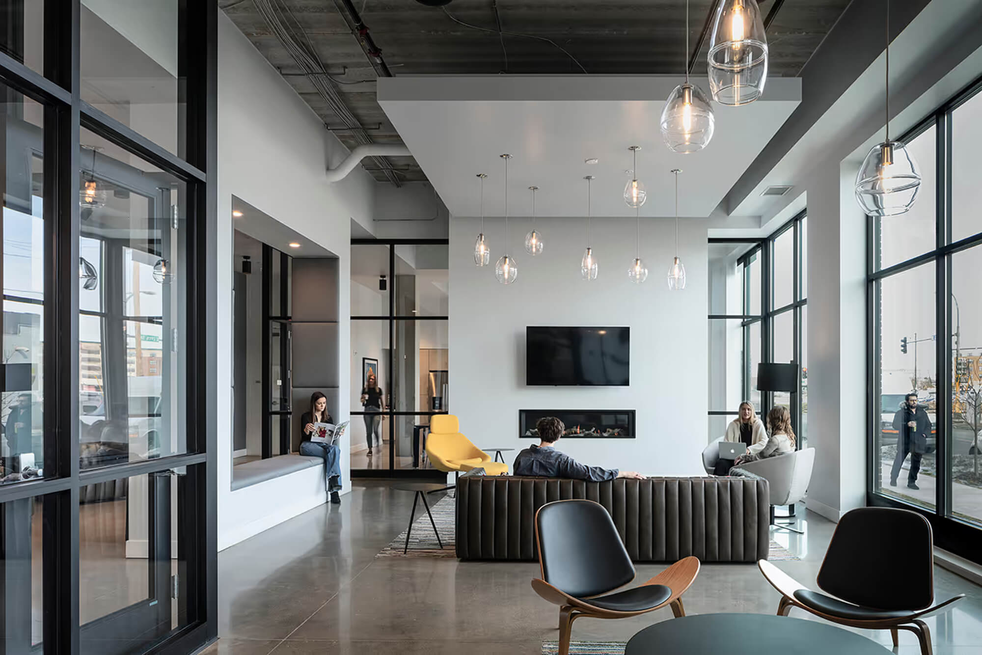 Lobby lounge with modern seating, fireplace, and tall windows