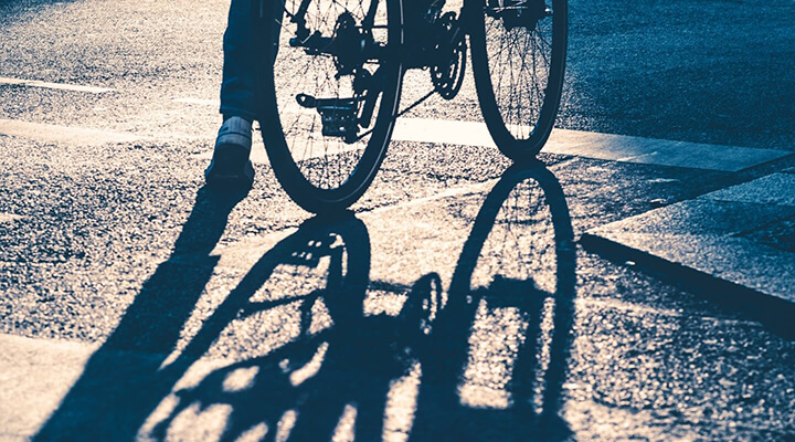 Close-up of a bicycle wheel and shadow on the pavement