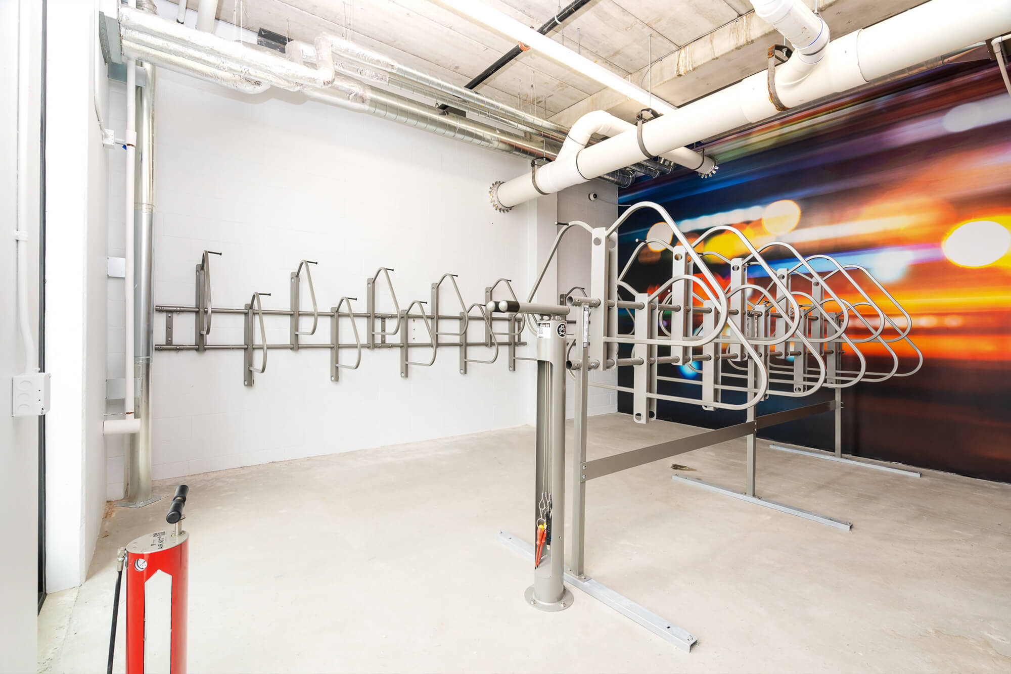 Secure indoor bike storage room with wall-mounted and freestanding bike racks.