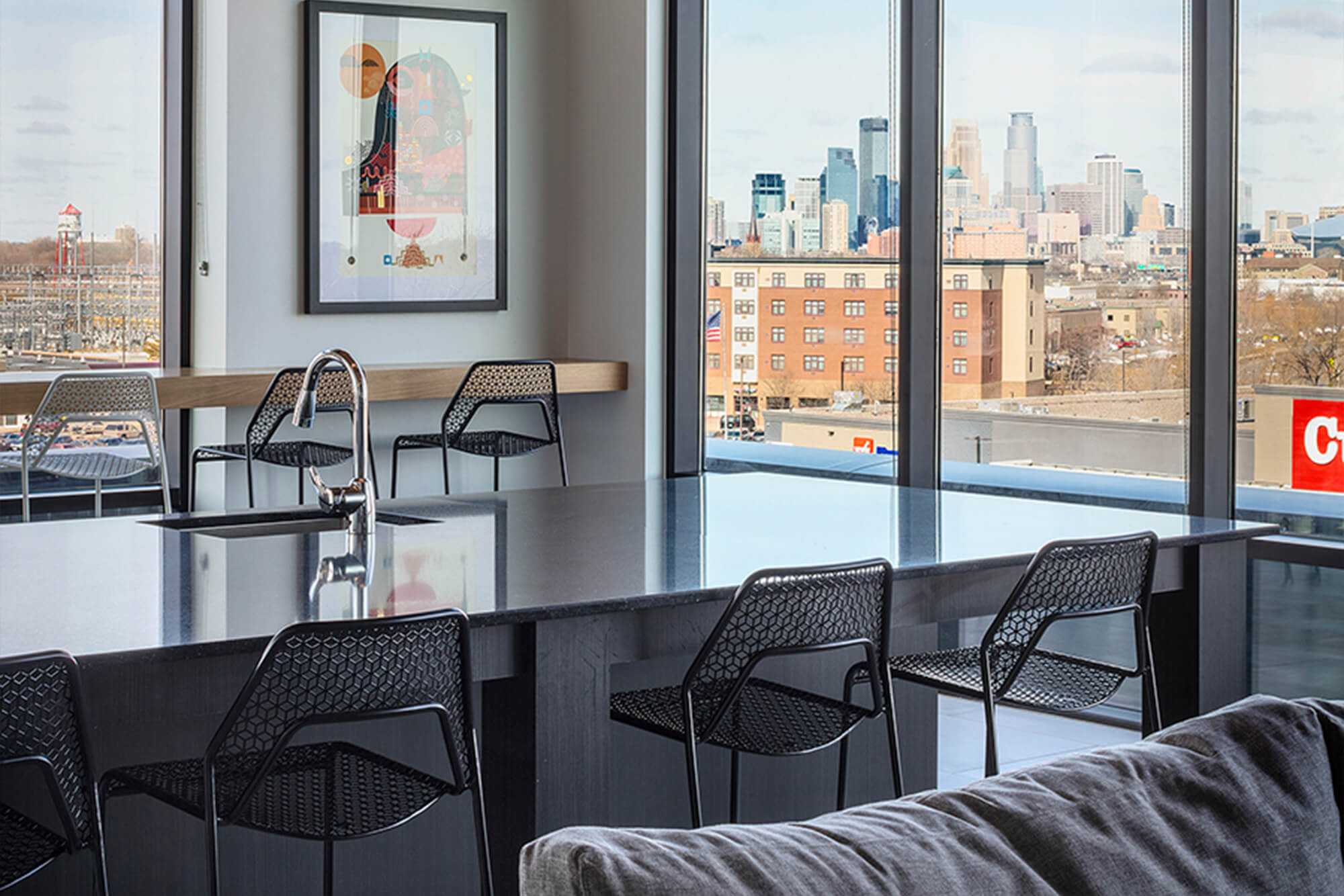 Indoor lounge with bar seating, large windows, and views of downtown Minneapolis.