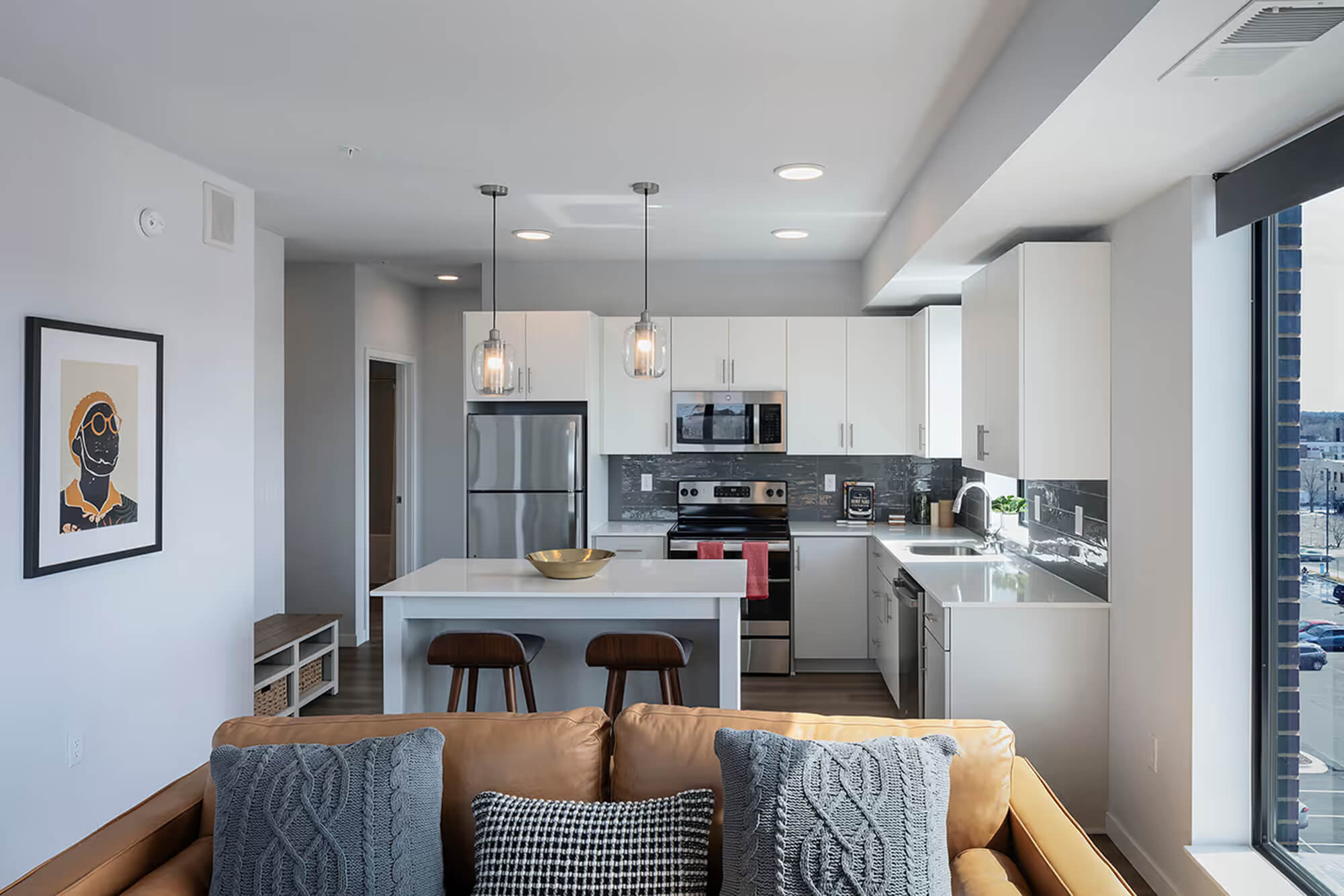 Studio apartment with open living area, kitchen, and large windows