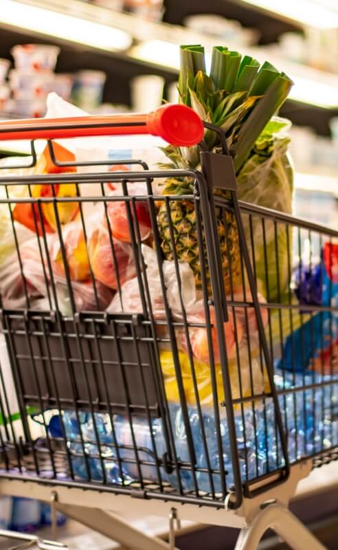 Grocery cart filled with fresh produce and groceries