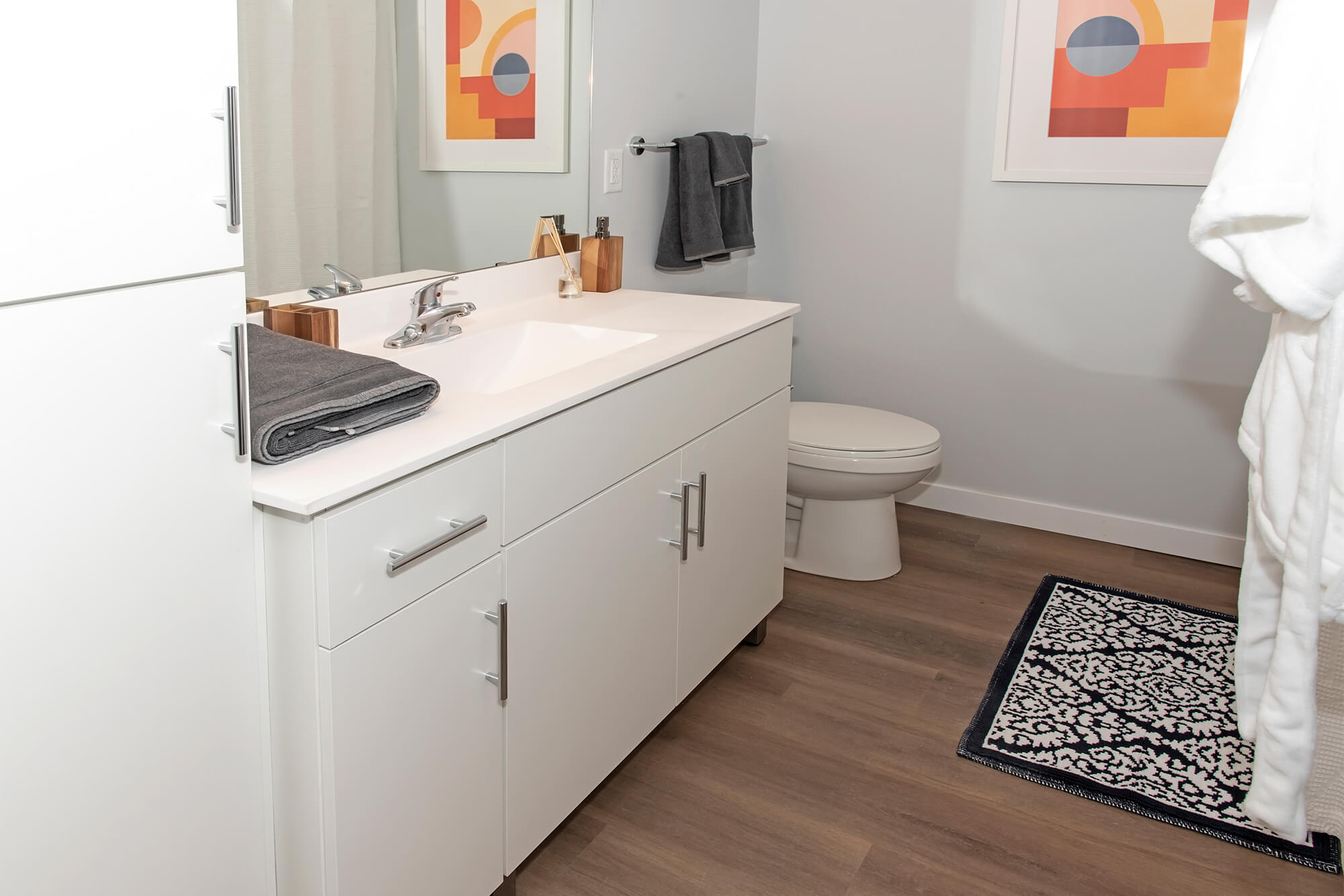 Modern bathroom with white vanity, toilet, and tub shower.