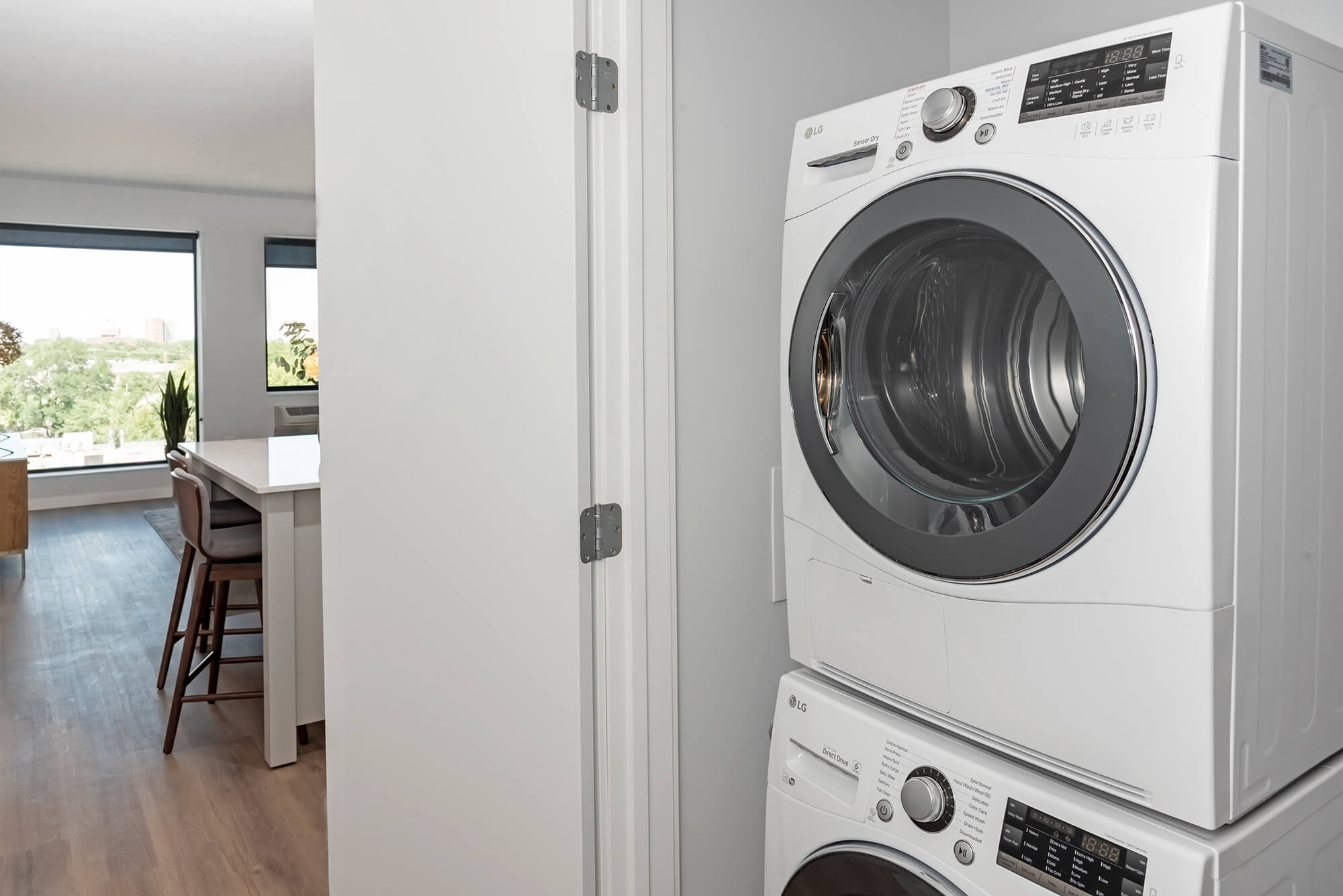 Stackable washer and dryer in an apartment laundry closet beside the kitchen.
